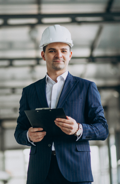 handsome business man engineer in hard hat in a building